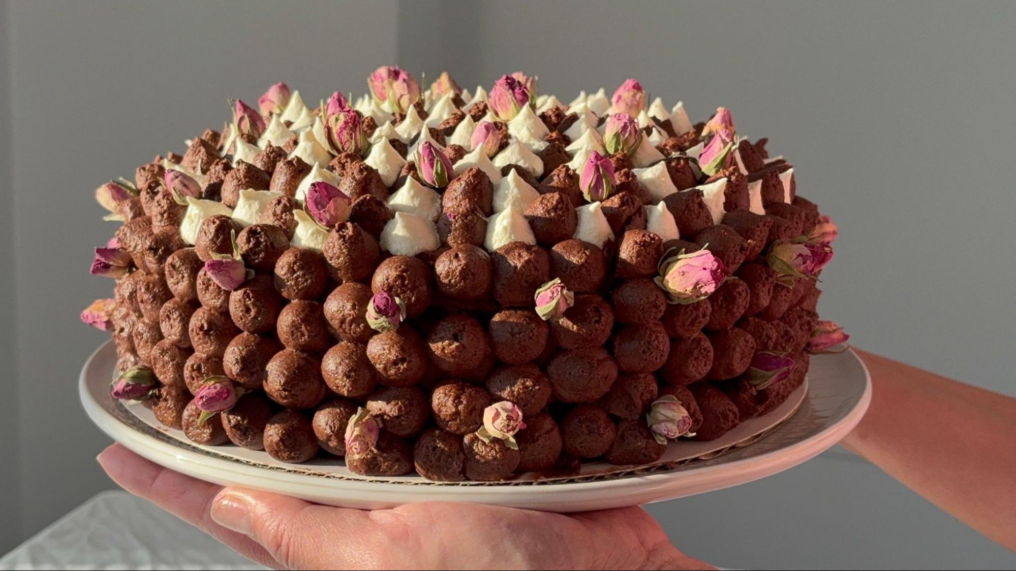 An Espresso Chocolate Cake with pink flower decorations